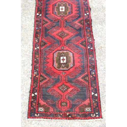 1300 - Old handwoven hall runner of red ground, approx 296 x 71cm