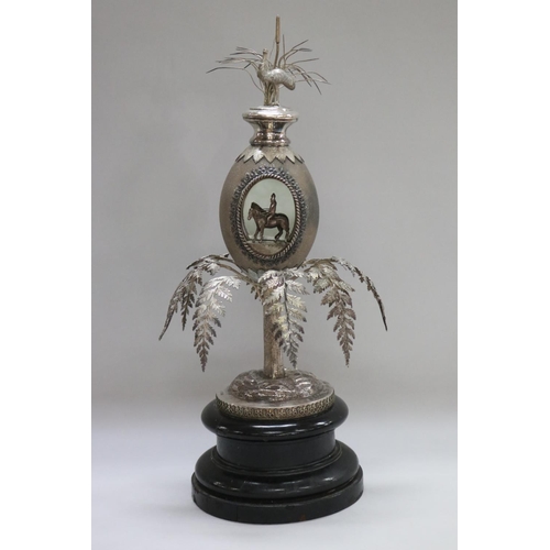 Important Australian emu egg horse racing trophy, with an inscription reading "1ST SYDNEY CUP 1866. WON BY YATTENDON. A horse & rider is standing in the open emu egg, while surmounted to a fern tree, along with a surmounted kangaroo to top, all standing on an ebonized wooden pedestal base, by William Kerr. Impressed mark W.KERR to base. This trophy is most likely a presentation piece as the original winning Sydney cup for Yattendon is held elsewhere. Ex private collection Queensland. Approx 44cm H