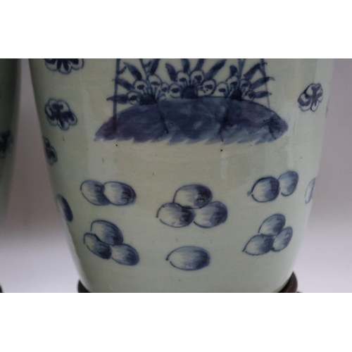 1017 - Pair of antique Chinese lidded celadon glaze urns, with blue storks, bats and fruit on rosewood stan... 