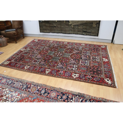 1026 - Vintage hand knotted garden pattern carpet of red ground, approx 206cm x 310cm
