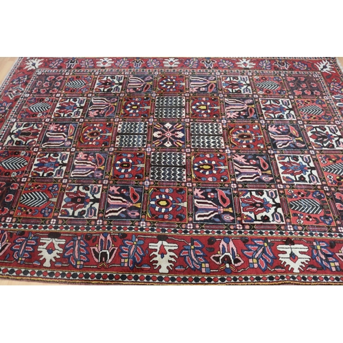 1026 - Vintage hand knotted garden pattern carpet of red ground, approx 206cm x 310cm
