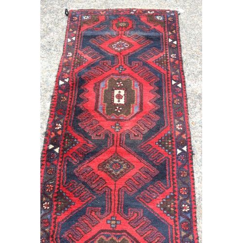 1047 - Vintage handwoven tribal hall runner of red ground, approx 296 x 71cm