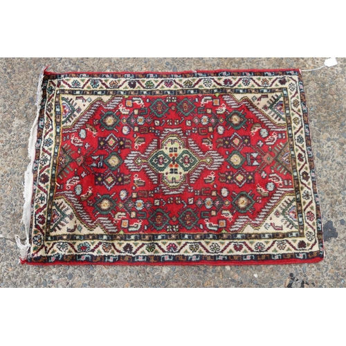 1107 - Persian Hand woven red ground carpet, approx 63cm x 87cm