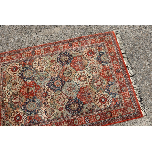 1060 - Persian style woollen garden pattern carpet, approx 180cm x 125cm