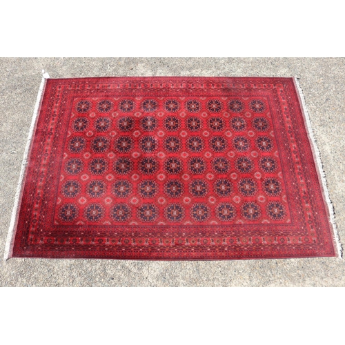 173 - Hand woven red ground carpet, approx 238cm x 162cm