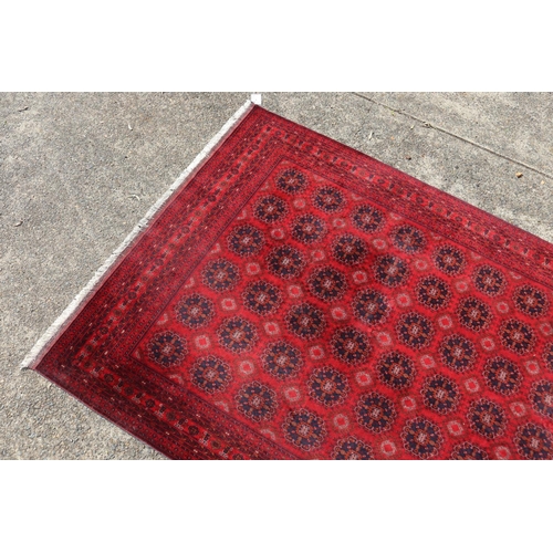 173 - Hand woven red ground carpet, approx 238cm x 162cm