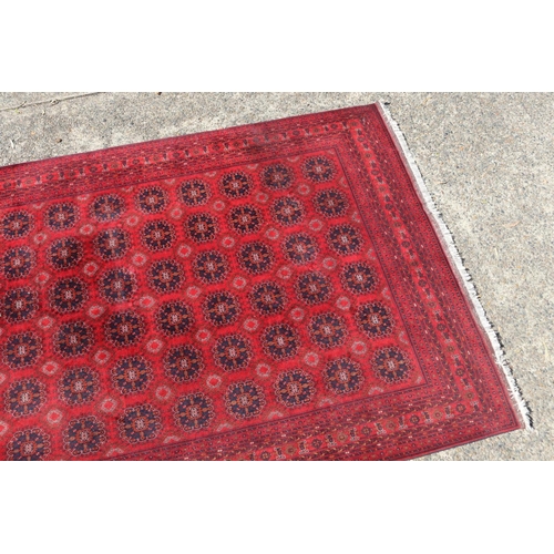 173 - Hand woven red ground carpet, approx 238cm x 162cm