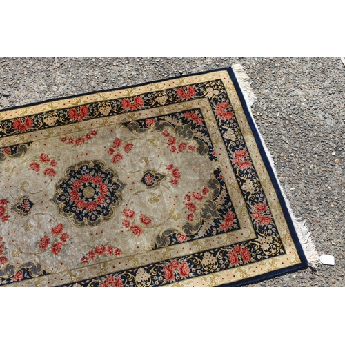 175 - Persian silk carpet with a design of stylised flower heads, approx 118cm x 77cm