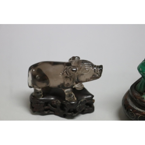 114 - Chinese Malachite carving of a frog, a crystal carved pig and a carnelian cat all on wooden stands, ... 