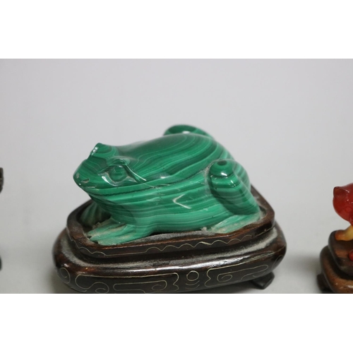 114 - Chinese Malachite carving of a frog, a crystal carved pig and a carnelian cat all on wooden stands, ... 