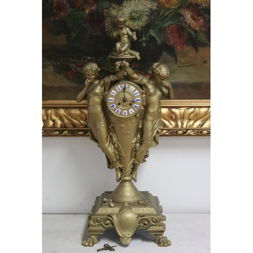 235 - French gold painted spelter mantle clock surmounted by two maidens and a putto, has key (in office D... 