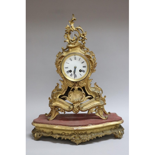 167 - Gilt metal Rococo style mantle clock on stand, has two keys and pendulum (in office D3615-1-109), un... 