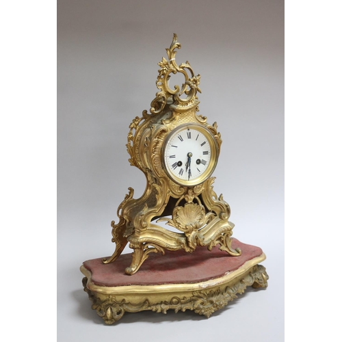 167 - Gilt metal Rococo style mantle clock on stand, has two keys and pendulum (in office D3615-1-109), un... 