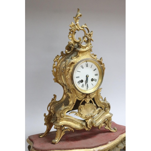 167 - Gilt metal Rococo style mantle clock on stand, has two keys and pendulum (in office D3615-1-109), un... 