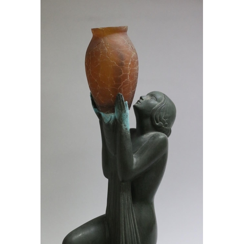 202 - Art Deco bronze table lamp in the form of a kneeling woman holding an amber glass vase, signed Guerl... 