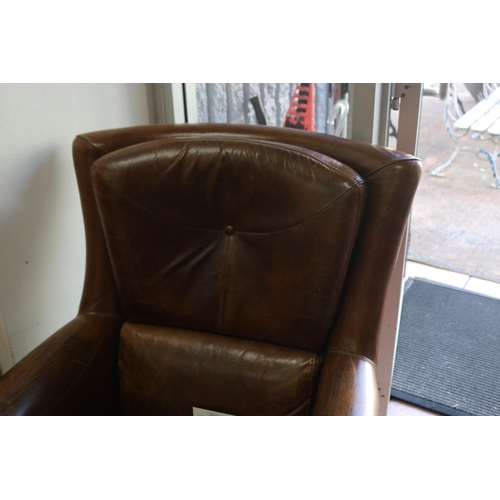 1022 - Good quality brown leather armchair, with brass studded trim, turned legs with brass castors, approx... 