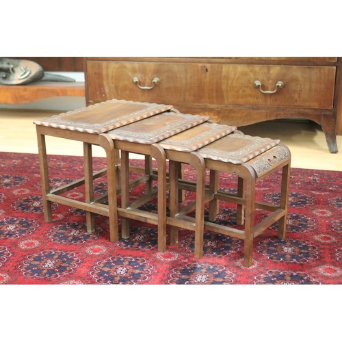 325 - Set of four Indian teak nesting tables with relief carved decoration, approx 38cm H x 46cm W x 29cm ... 