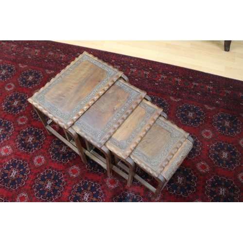 325 - Set of four Indian teak nesting tables with relief carved decoration, approx 38cm H x 46cm W x 29cm ... 