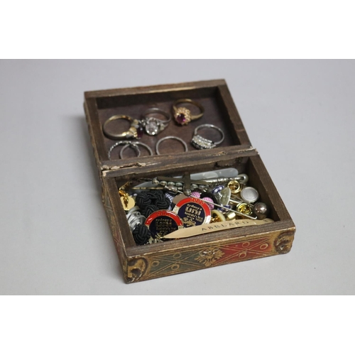 286 - Assortment of costume jewellery in a wooden box to include rings, cufflinks, some silver etc