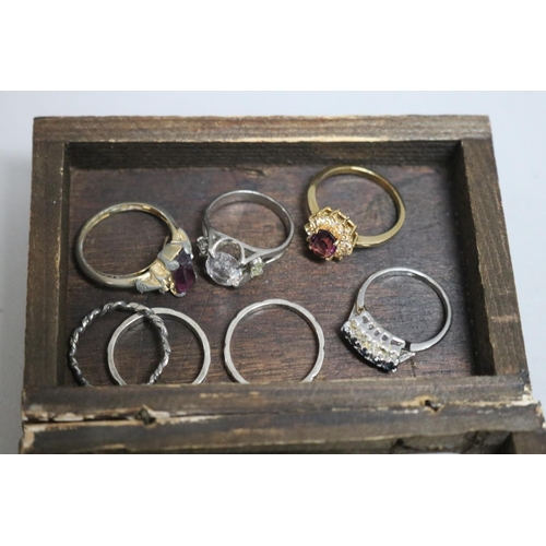 286 - Assortment of costume jewellery in a wooden box to include rings, cufflinks, some silver etc