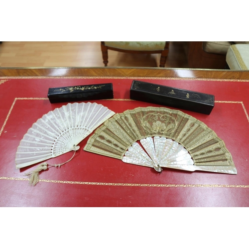 304 - Two Chinese export fans in lacquer cases, one with mother of pearl sticks & the other with pierced b... 