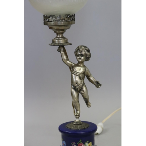 51 - French figural lamp of a putti holding a torch, standing on a porcelain pedestal base, approx 51cm H