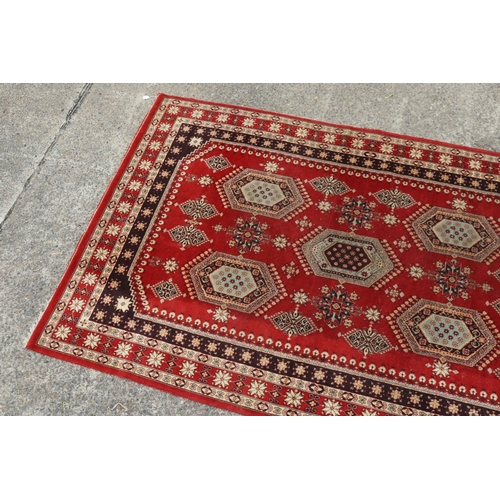 58 - Handwoven carpet of red ground, approx 197cm x 310cm