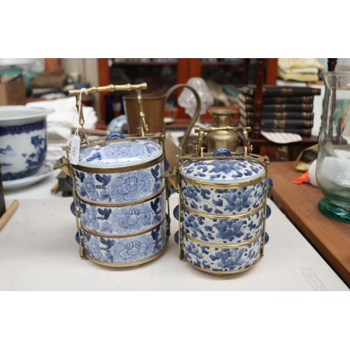 157 - Two Chinese blue and white tiered food containers, with brass carrry handles and frame work, approx ... 