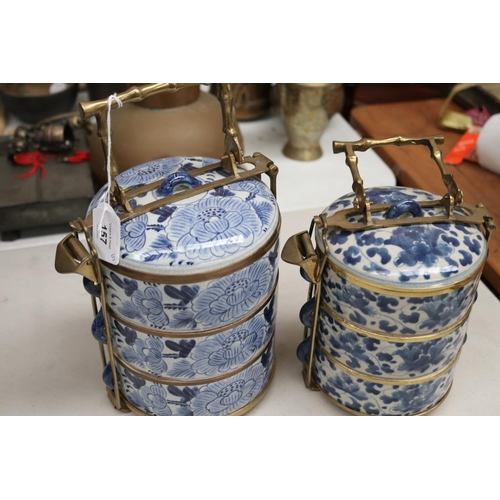 157 - Two Chinese blue and white tiered food containers, with brass carrry handles and frame work, approx ... 