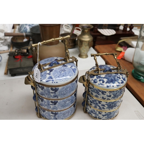 157 - Two Chinese blue and white tiered food containers, with brass carrry handles and frame work, approx ... 