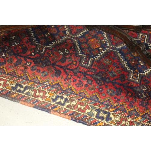 214 - Tribal hand knotted wool carpet, of red ground, approx 117cm x 185cm