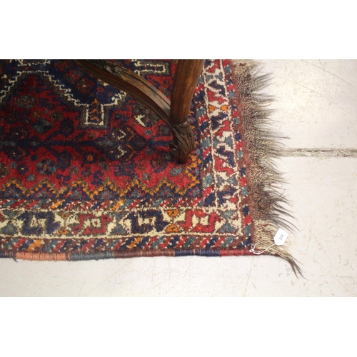 214 - Tribal hand knotted wool carpet, of red ground, approx 117cm x 185cm