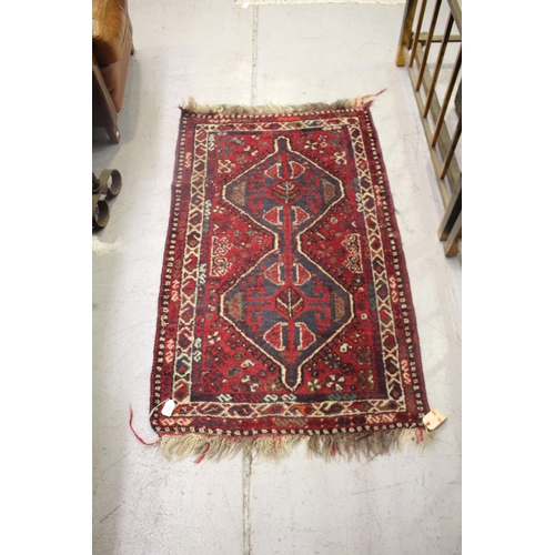 242 - Hand woven tribal wool carpet, two central guls, approx 81cm x 138cm