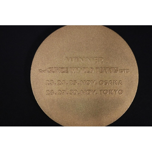 1320 - Tennis trophy medal. Inscribed, GUNZE WORLD TENNIS. WINNER 2ND GUNZE WORLD TENNIS 1975 23.24.25.NOV.... 