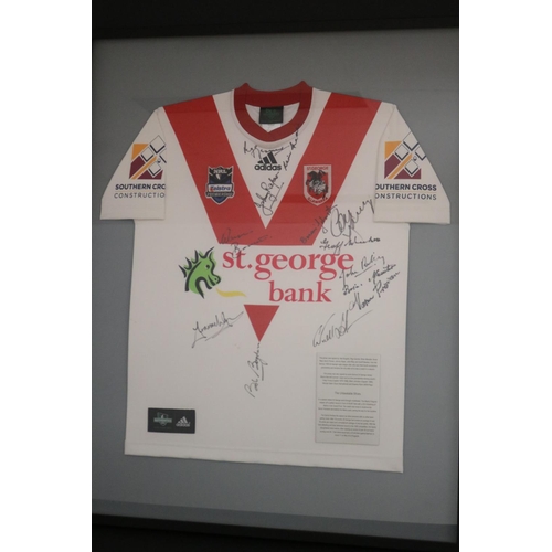 1410 - Framed & signed St George Dragons jersey.

Plaque reads: This jersey was signed by: Bob Bugden, Reg ... 