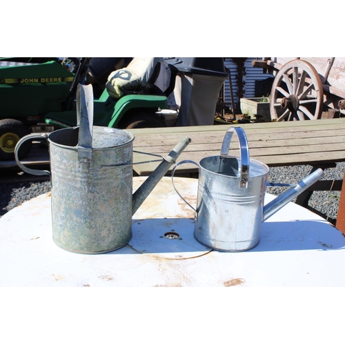 113 - Antique gal metal watering can along with a modern example, approx 40cm H x 45cm W and smaller (2)
