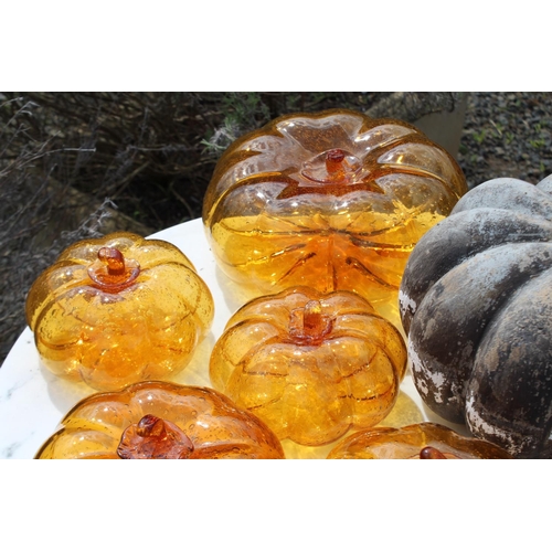 127 - Seven pumpkins, six amber glass and one pottery, approx 23cm Dia and smaller  (7) please note an ext... 