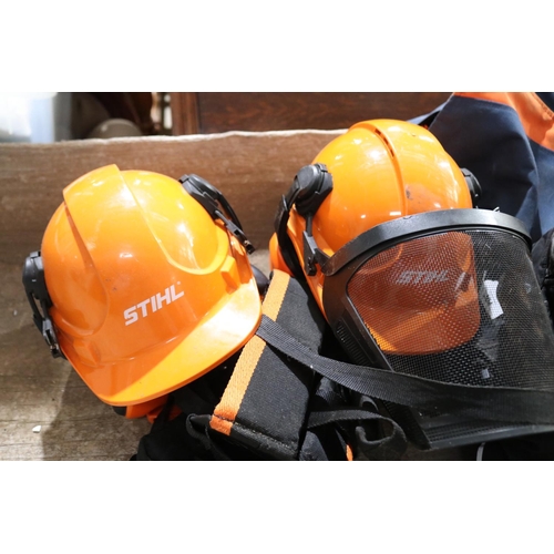 304 - Two as new Stihl helmets and ear protective wear, along with protective pants and chaps