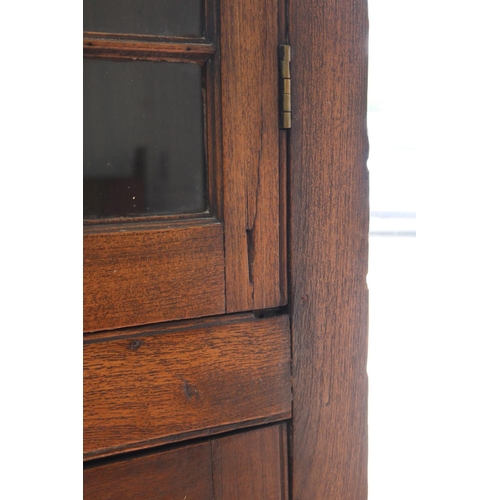234 - Antique Georgian cedar two height corner cabinet, astral glazed two door top, recessed paneled two d... 