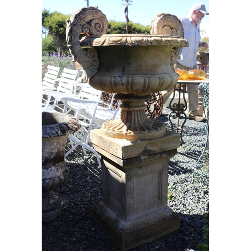21 - Large composite stone rollover rimed garden urn, with applied scrolling handles, on square pedestal ... 