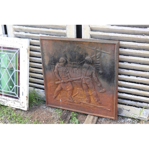 193 - Antique French cast iron fire back, cast in relief with a blacksmithing scene, approx 66cm x 66cm