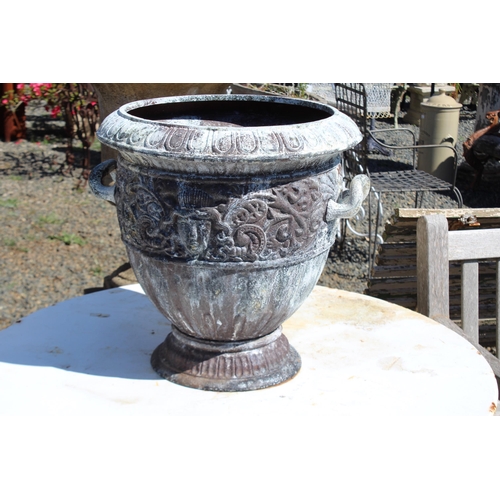 142 - Large antique French cast iron twin handled urn, cast in relief with mask heads of Medusa and scroll... 