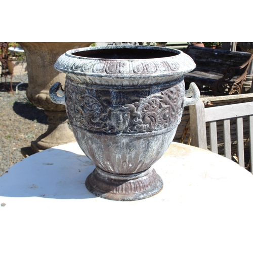 142 - Large antique French cast iron twin handled urn, cast in relief with mask heads of Medusa and scroll... 