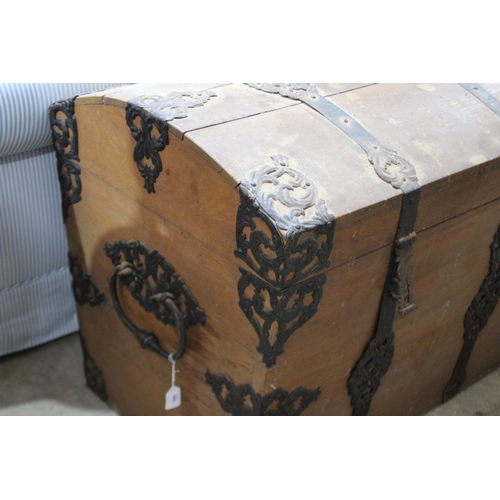 583 - Large antique European pierced metal mounted trunk, domed topped, the ends fitted with large iron ca... 