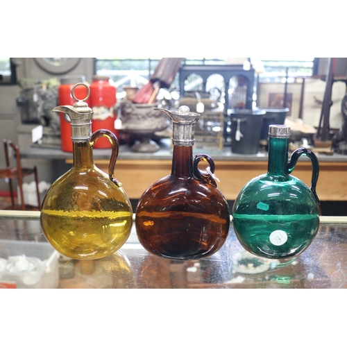 1346 - Three antique English Bristol coloured glass decanters. each with metal mounts, in green, brown, amb... 