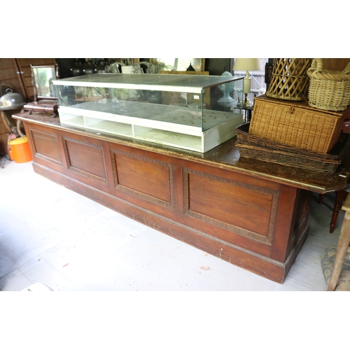 2591 - Antique silky oak and pine long shop counter, four recessed panel front, approx 85cm H x 374cm L x 7... 