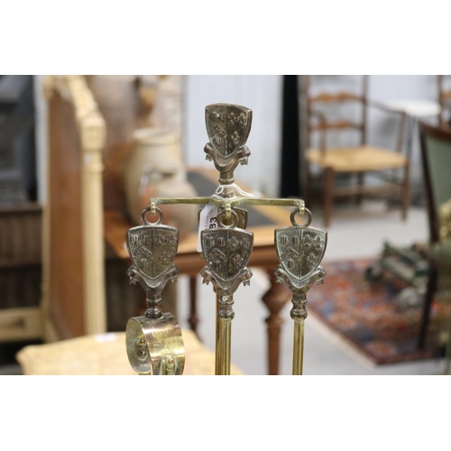 383 - Vintage French brass fire mantle set on stand, decorated with armorial crest to handles