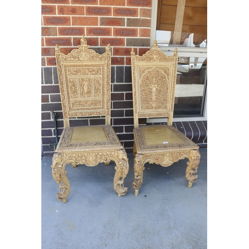 367 - Two similar of profusely carved Thai teak chairs (2)