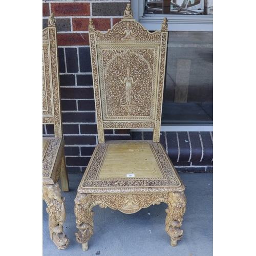 367 - Two similar of profusely carved Thai teak chairs (2)