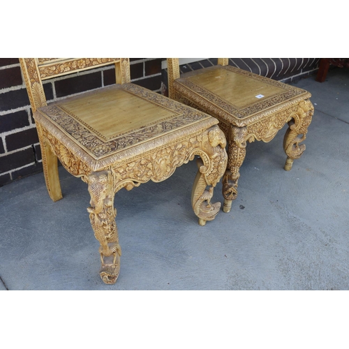 367 - Two similar of profusely carved Thai teak chairs (2)